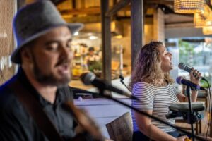 Two performers from Any Grooves on stage at The DeckHouse, An Bang Beach, playing live music during the Christmas Eve party in Hoi An.